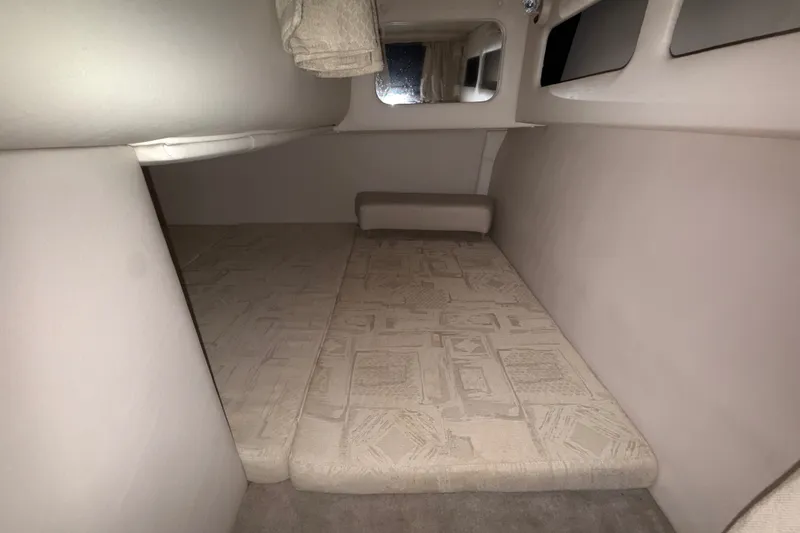 Slide: The Image of 2005 Crownline 270 CR cabin interior with beige upholstery and compact sleeping area. - 47