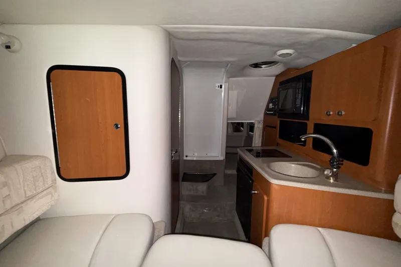 Slide: The Image of Interior of a 2005 Crownline 270 CR boat with kitchenette and seating area. - 37