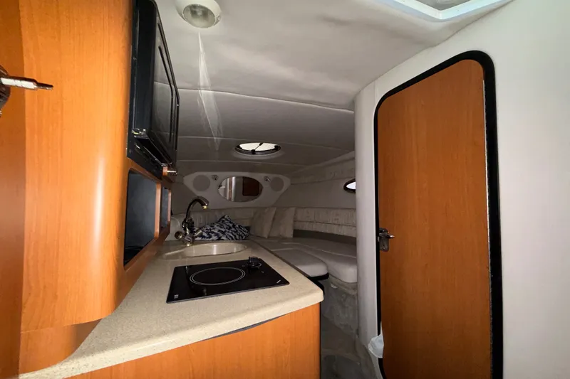 Slide: The Image of Interior of 2005 Crownline 270 CR boat with kitchenette and seating area. - 51