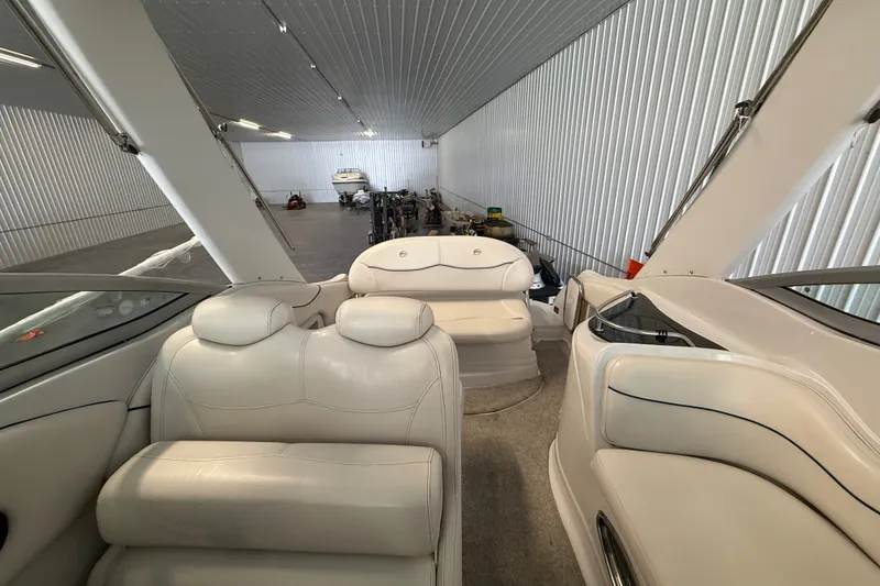 Slide: The Image of Interior of 2005 Crownline 270 CR boat in storage, featuring white seating and modern design. - 26