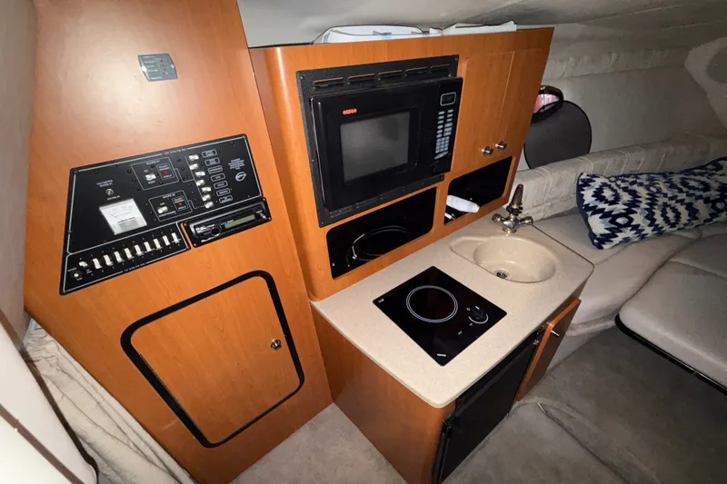 Slide: The Image of 2005 Crownline 270 CR cabin interior with kitchenette, microwave, and control panel. - 31