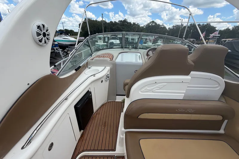 Slide: The Image of 2006 Sea Ray 300 Sundancer boat interior with brown seating and wood flooring. - 12