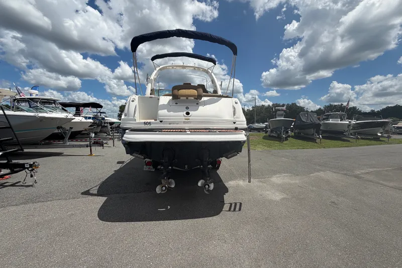 Slide: The Image of 2006 Sea Ray 300 Sundancer boat parked under a cloudy sky at a marina. - 3