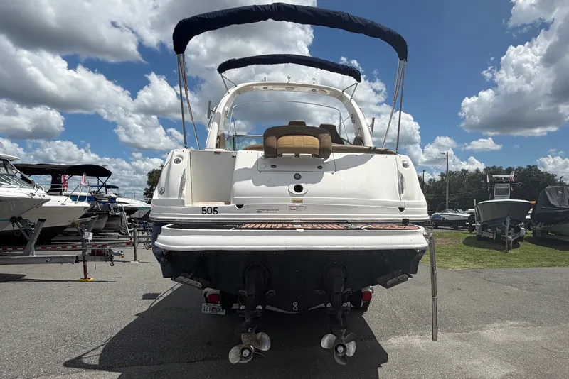 Slide: The Image of 2006 Sea Ray 300 Sundancer boat parked under a cloudy sky at a marina. - 3
