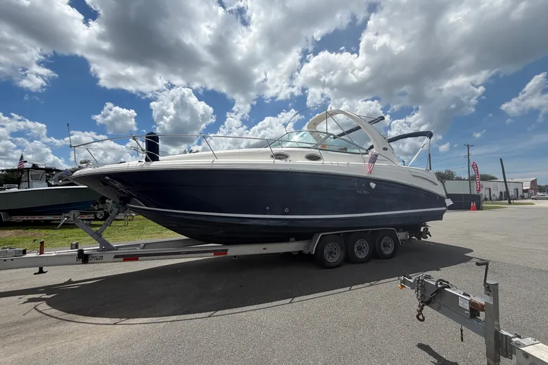 Slide: The Image of 2006 Sea Ray 300 Sundancer boat on trailer under cloudy sky. - 1