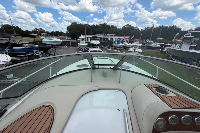 Slide: The Image of 2006 Sea Ray 300 Sundancer boat at a marina, surrounded by other vessels. - 21