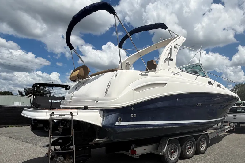 Slide: The Image of 2006 Sea Ray 300 Sundancer boat on trailer under cloudy sky. - 2