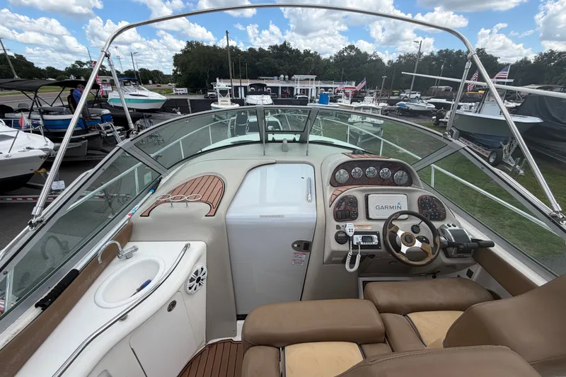 Slide: The Image of 2006 Sea Ray 300 Sundancer cockpit with Garmin navigation, docked among other boats. - 13
