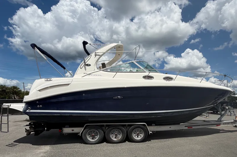 Slide: The Image of 2006 Sea Ray 300 Sundancer boat on trailer under cloudy sky. - 1