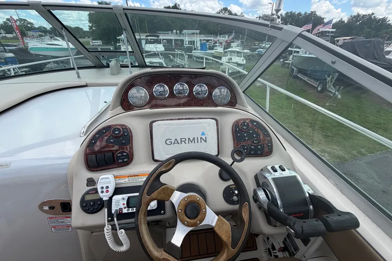 Slide: The Image of 2006 Sea Ray 300 Sundancer helm with Garmin navigation system and steering wheel. - 15