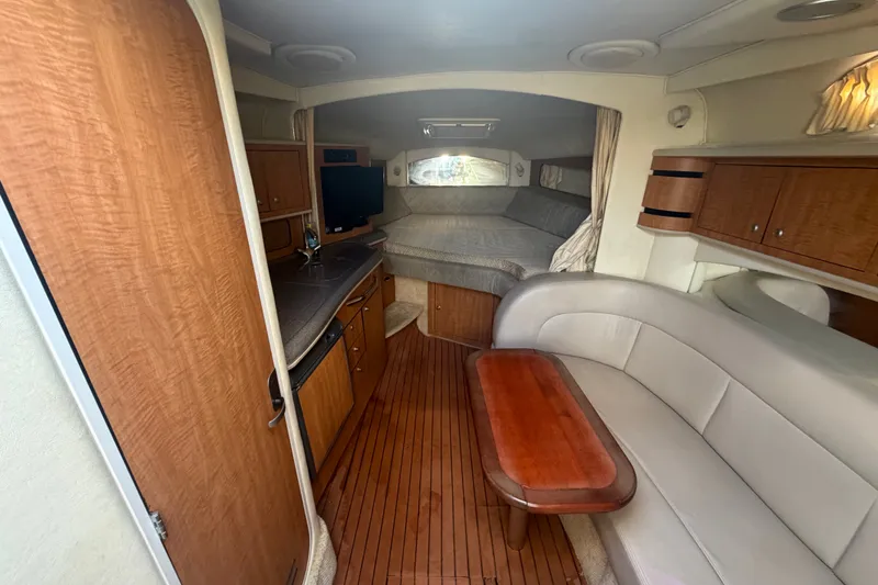 Slide: The Image of Interior of 2006 Sea Ray 300 Sundancer with wood accents and cozy seating area. - 19