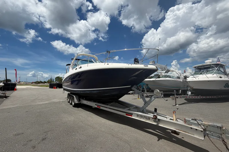Slide: The Image of 2006 Sea Ray 300 Sundancer boat on trailer under a partly cloudy sky. - 6