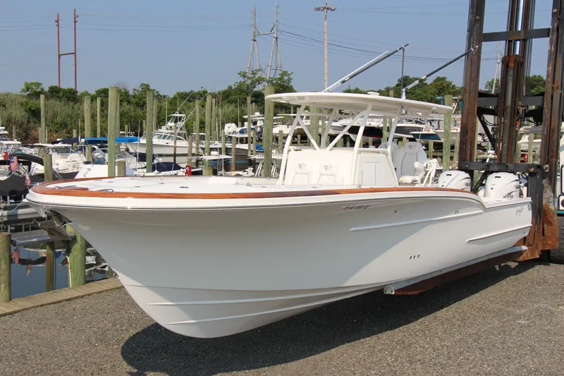 Slide: The Image of 2019 Buddy Davis 34 Center Console boat at marina, showcasing sleek design and powerful engines. - 21