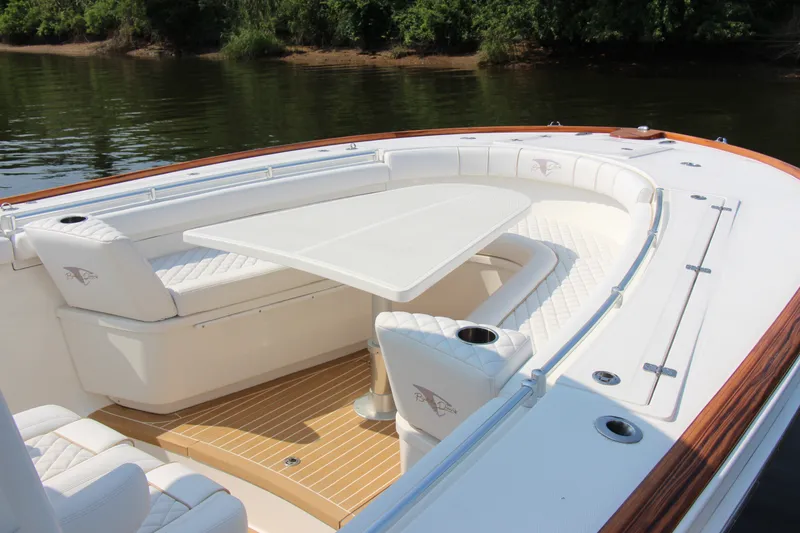 Slide: The Image of 2019 Buddy Davis 34 Center Console boat with elegant seating and table on calm water. - 25