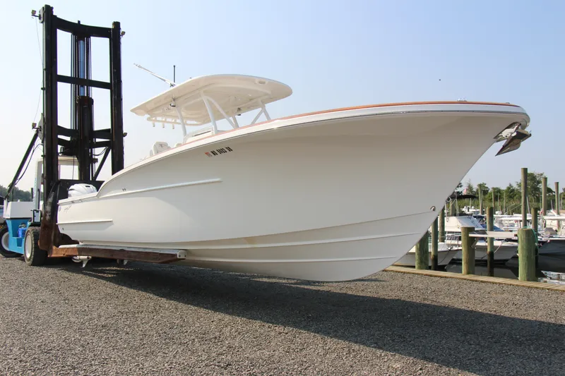 Slide: The Image of 2019 Buddy Davis 34 Center Console boat on forklift at marina. - 17