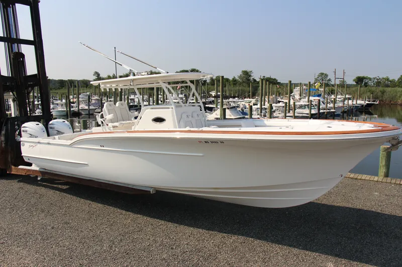 Slide: The Image of 2019 Buddy Davis 34 Center Console boat docked at a marina, featuring twin Yamaha engines. - 16