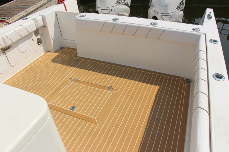 Slide: The Image of 2019 Buddy Davis 34 Center Console boat deck with teak flooring and dual outboard engines. - 32