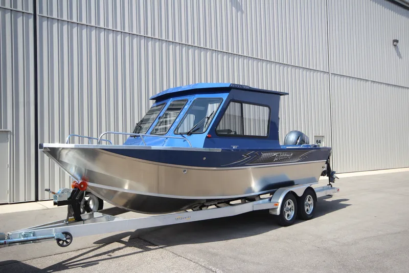 The Image of 2027 Weldcraft 210 Revolution boat on trailer, parked outside a large building. - 0