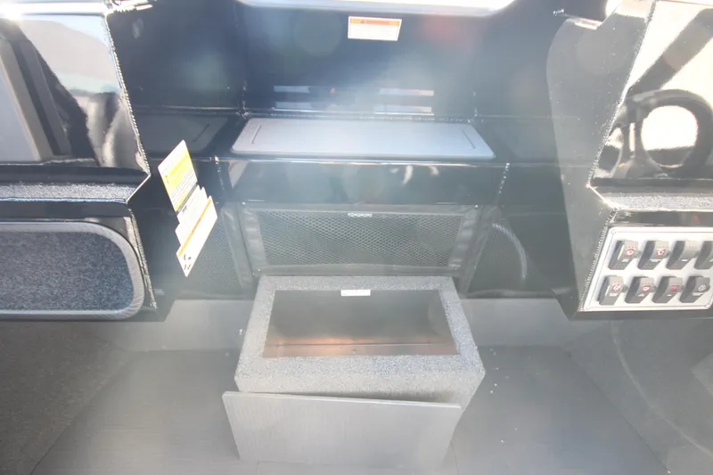 Slide: The Image of 2025 Weldcraft 210 Revolution Soft Top interior dashboard with control panel and storage compartments. - 19