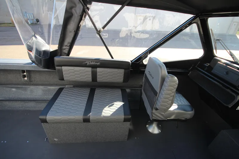 Slide: The Image of 2025 Weldcraft 210 Revolution Soft Top interior with seating and dashboard view. - 13