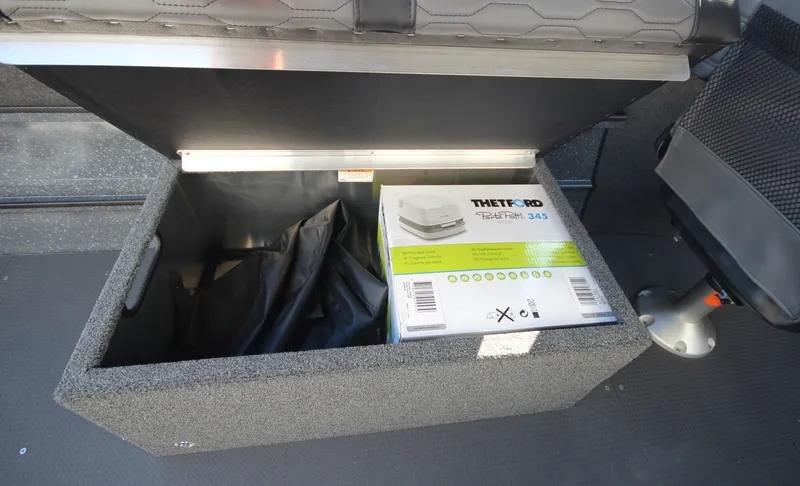Slide: The Image of Open storage compartment in 2025 Weldcraft 210 Revolution boat with Thetford Porta Potti. - 14