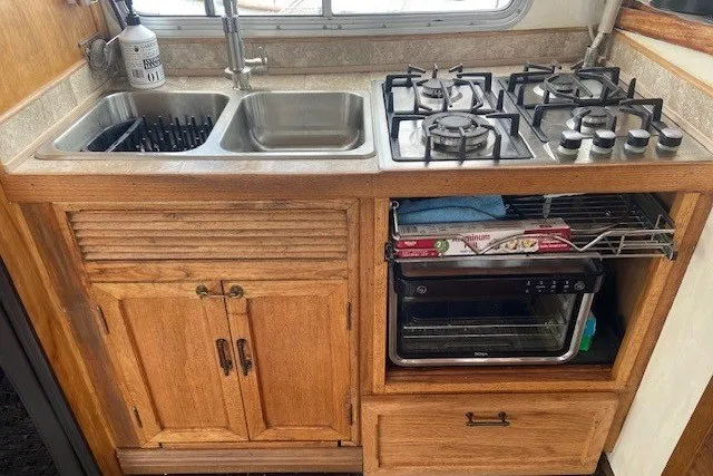 Slide: The Image of Wooden kitchen area in a 1979 SUNYONG PS Trawler with stove, sink, and oven. - 23