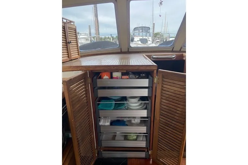 Slide: The Image of Wooden cabinet with open doors revealing organized storage drawers on a 1979 SUNYONG PS Trawler. - 24