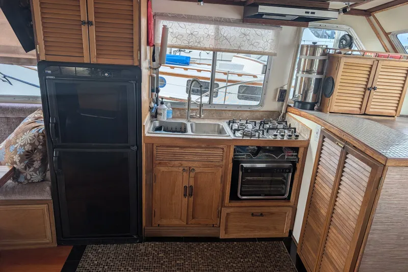 Slide: The Image of Cozy kitchen in a 1979 SUNYONG PS Trawler with stove, sink, and fridge. - 22
