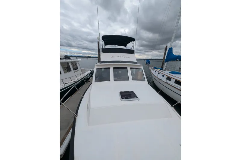 Slide: The Image of 1979 SUNYONG PS Trawler docked between boats under cloudy skies. - 11