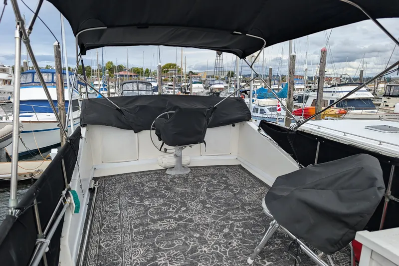 Slide: The Image of 1979 SUNYONG PS Trawler boat deck with covered seating, docked in a marina. - 3