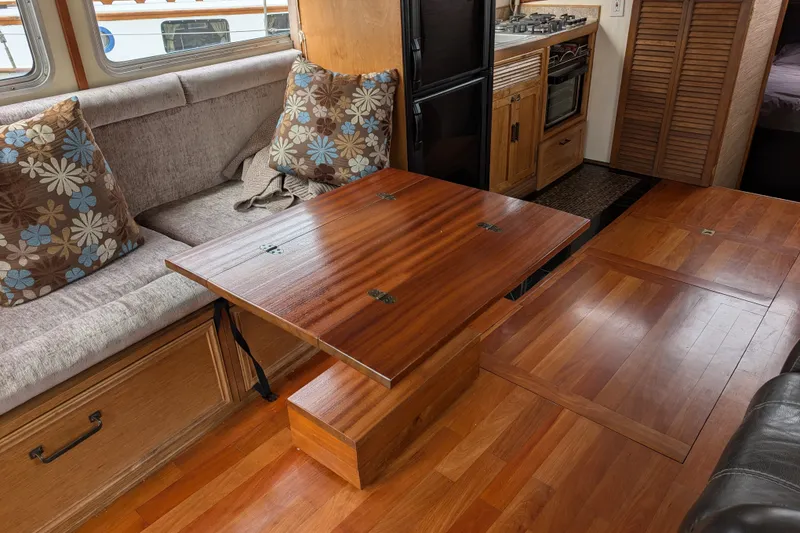Slide: The Image of Interior of 1979 SUNYONG PS Trawler with wooden table, seating, and kitchen area. - 13