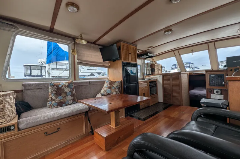 Slide: The Image of Interior of 1979 SUNYONG PS Trawler with cozy seating, wooden table, and nautical decor. - 14