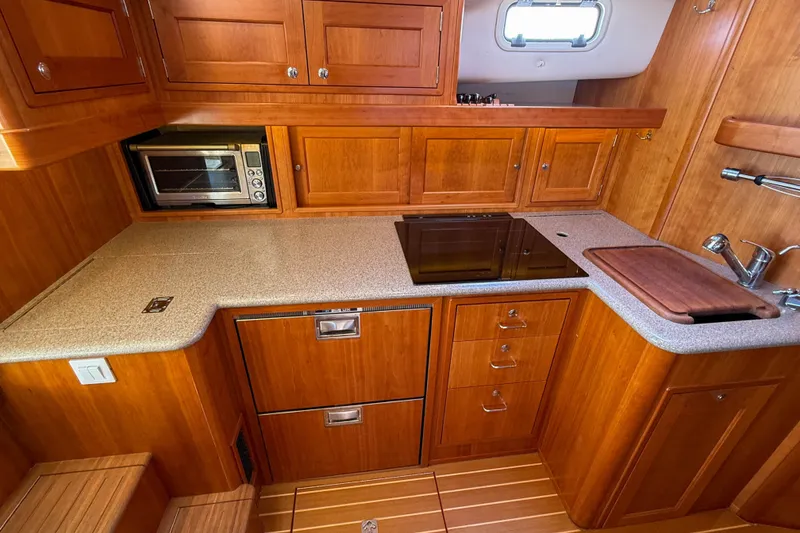 Slide: The Image of Luxurious 2017 MJM 50z yacht kitchen with wood cabinetry and modern appliances. - 31