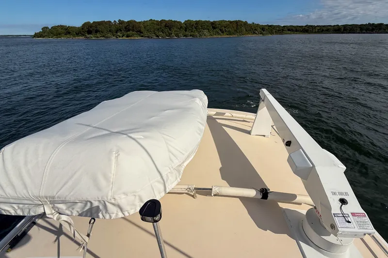 Slide: The Image of 2017 MJM 50z yacht deck with covered equipment, overlooking serene water and lush shoreline. - 55