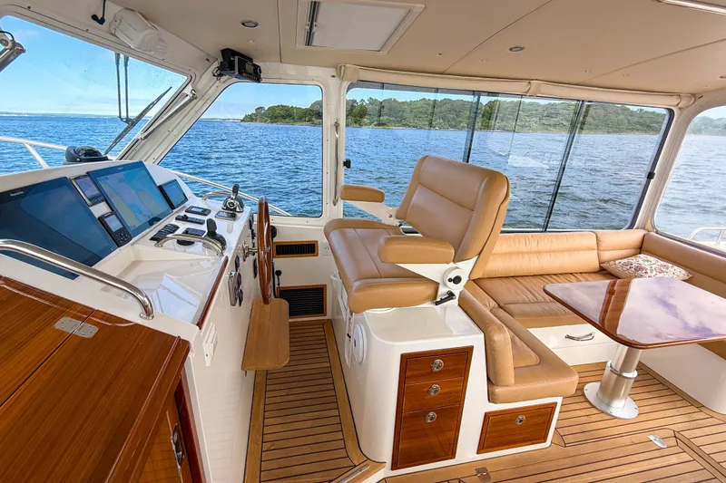 Slide: The Image of Luxurious 2017 MJM 50z yacht interior with leather seating, wooden accents, and navigation equipment. - 21