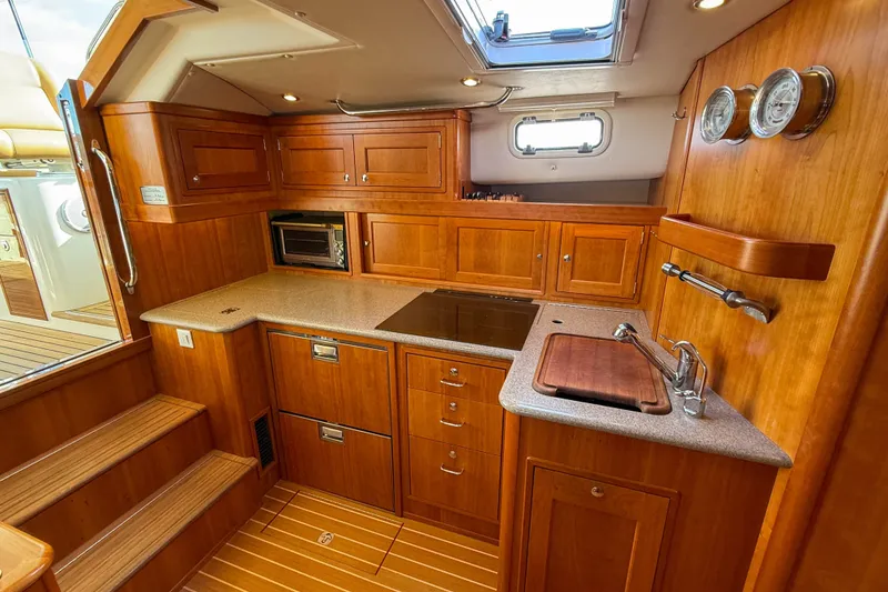 Slide: The Image of Luxurious 2017 MJM 50z yacht kitchen with wood cabinetry and modern appliances. - 32