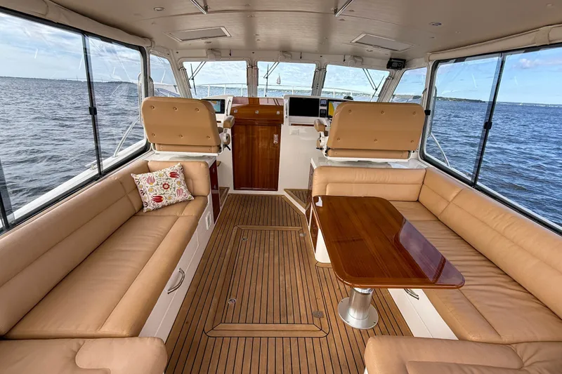 Slide: The Image of Luxurious 2017 MJM 50z yacht interior with beige seating and wooden table on open water. - 14