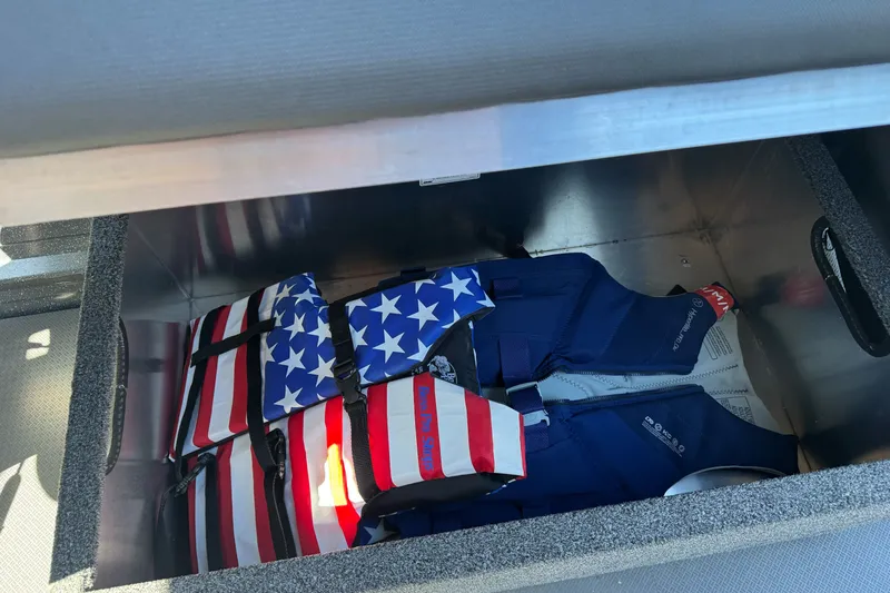 Slide: The Image of Storage compartment in a 2025 Duckworth 20 Advantage boat with American flag life jackets. - 22