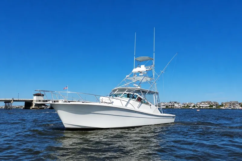 Slide: The Image of 2006 Topaz 40 Express boat on water under clear blue sky. - 3
