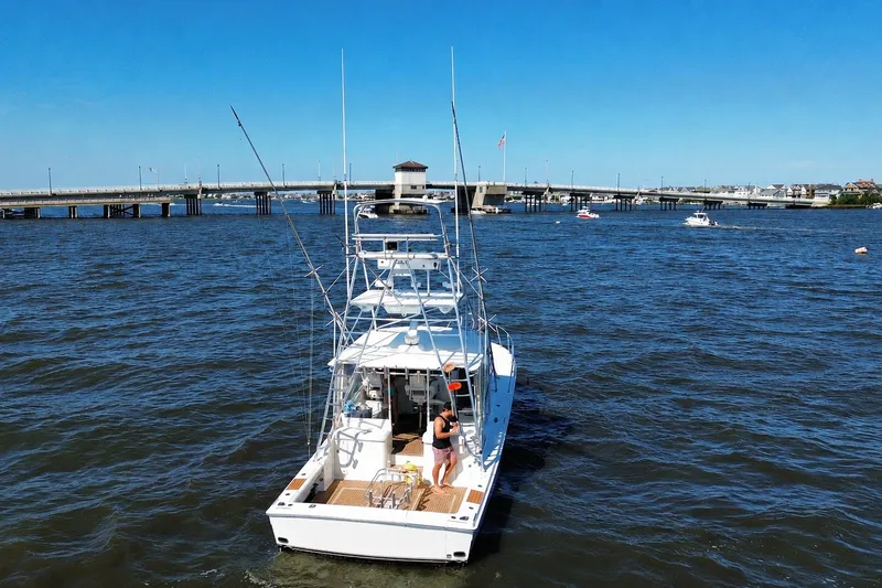 Slide: The Image of 2006 Topaz 40 Express boat on water near a bridge under clear blue sky. - 9