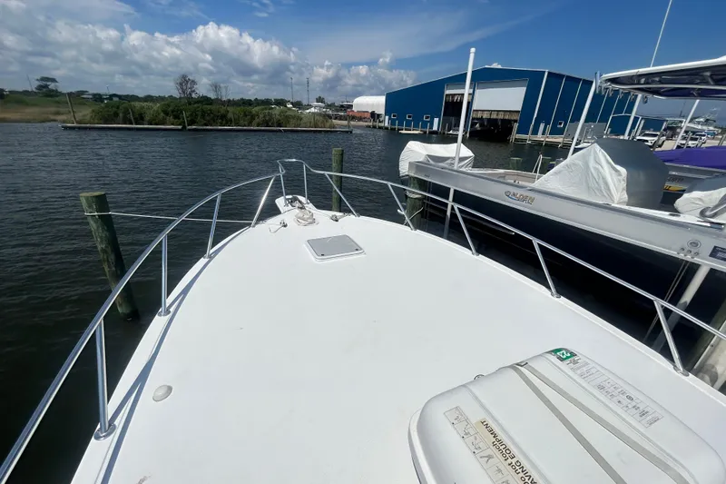 Slide: The Image of 2006 Topaz 40 Express boat docked at marina with clear sky and water view. - 25
