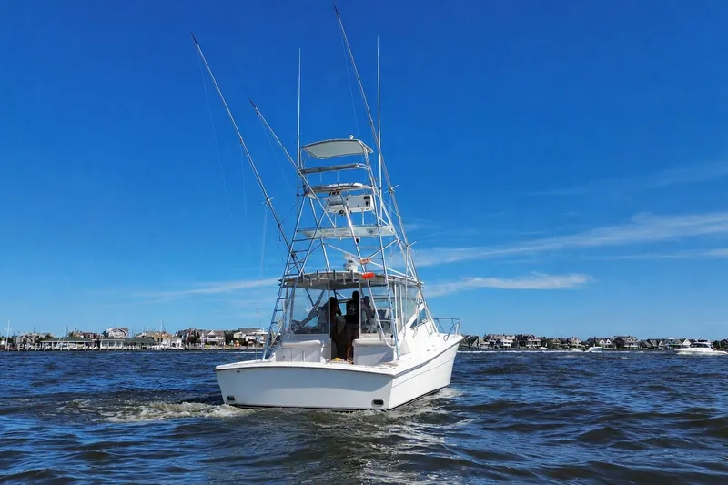 Slide: The Image of 2006 Topaz 40 Express boat cruising on open water under clear blue sky. - 6