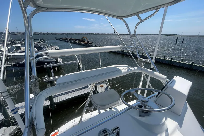 Slide: The Image of 2006 Topaz 40 Express boat helm with marina view, featuring steering wheel and seating. - 22