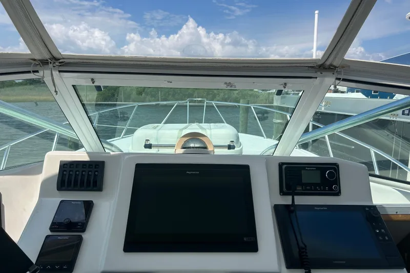 Slide: The Image of Helm view of 2006 Topaz 40 Express boat with navigation equipment and clear skies. - 18