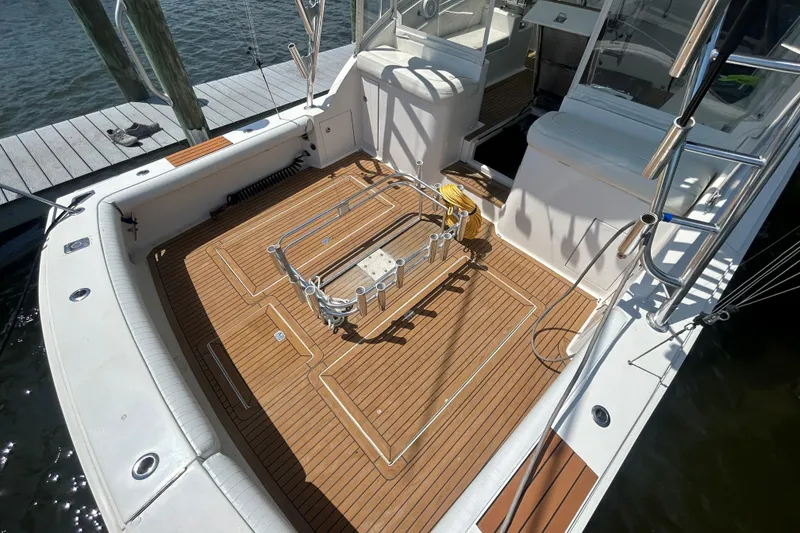 Slide: The Image of 2006 Topaz 40 Express boat deck with teak flooring and fishing rod holders. - 28