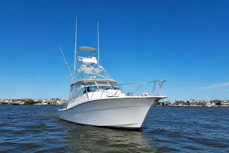Slide: The Image of 2006 Topaz 40 Express yacht on calm water under clear blue sky. - 4