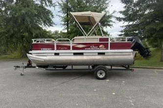 The Image of 2018 Sun Tracker Bass Buggy 18 DLX pontoon boat on trailer, parked outdoors. - 0