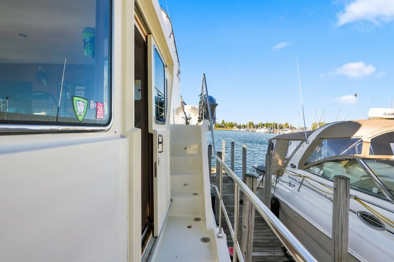 Slide: The Image of 2015 North Pacific NP49 yacht docked at marina, clear blue sky, calm waters. - 58