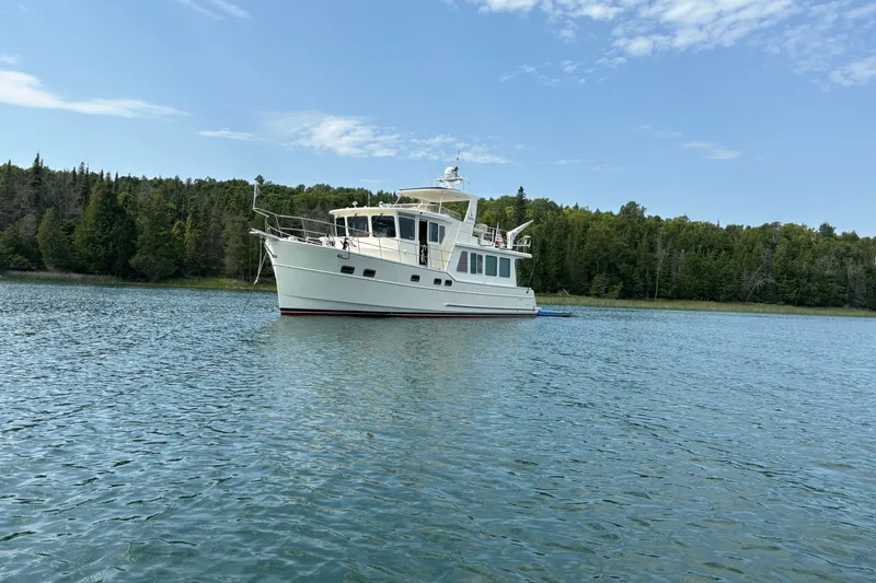 The Image of 2015 North Pacific NP49 yacht anchored on serene lake with forested shoreline. - 0