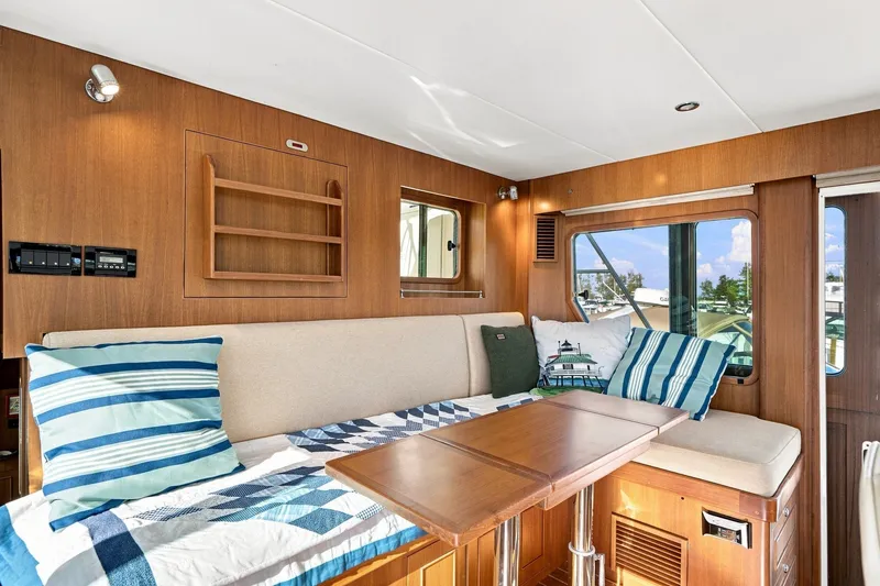 Slide: The Image of Cozy interior of 2015 North Pacific NP49 yacht with striped cushions and wooden accents. - 19
